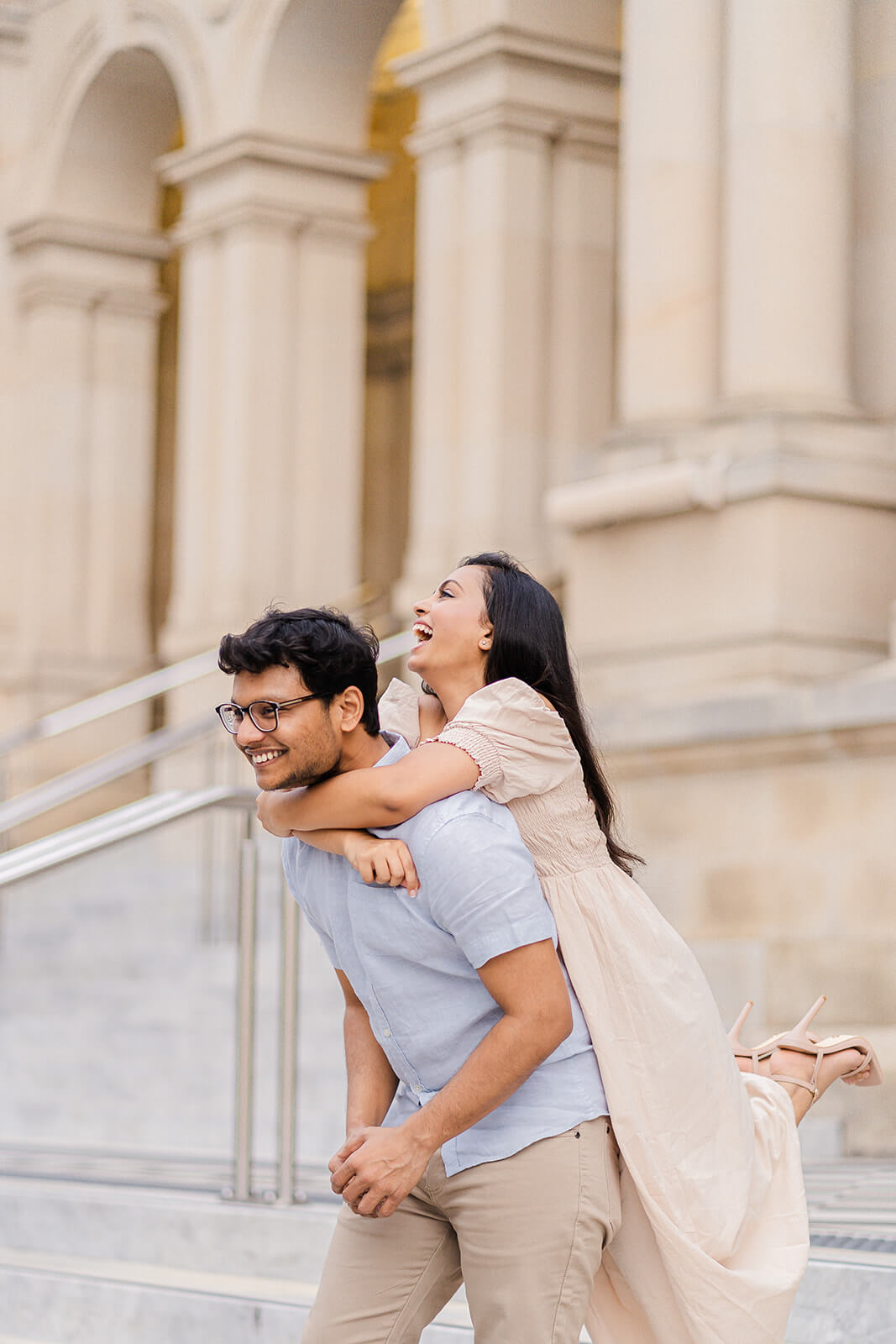 candid shot indian couple piggyback laughing for engagement photos in brisbane.